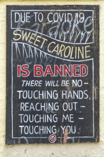 Sign outside pub advising that handshaking and touching is prohibited during the song Sweet