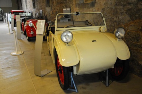 Deutsches Automuseum Langenburg, A small white vintage car in a museum, next to an information