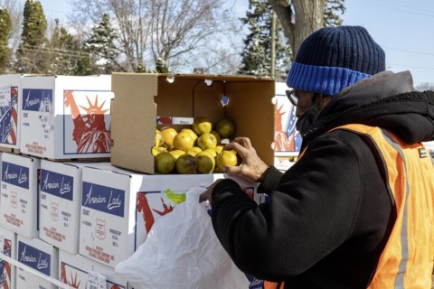 Detroit, Michigan, Free food is distributed to people attending a community health fair. A worker