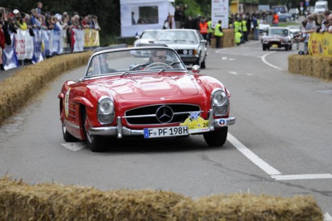 A red Mercedes 300SL Roadster on a race track, accompanied by spectators, SOLITUDE REVIVAL 2011,