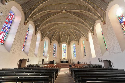 Speyer Cathedral, interior view of a church with wooden benches, high vaults and stained glass