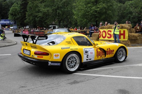 Rear view of a yellow racing car with sponsor logos on a race track at an event, SOLITUDE REVIVAL