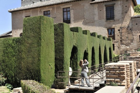 Patio de Machuca, Alhambra, Granada, Garden path with dense green hedges and two people in the