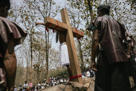 Christian devotees takes part in a perform to re-enactment of the crucifixion of Jesus Christ