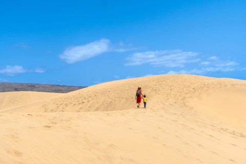 (Varios valores) Mother and son walking in the dunes of Maspalomas on vacation, Gran Canaria,