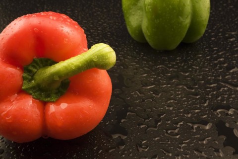 Close-up of freshly picked and washed red and green Capsicum annuum, Bell Peppers on black