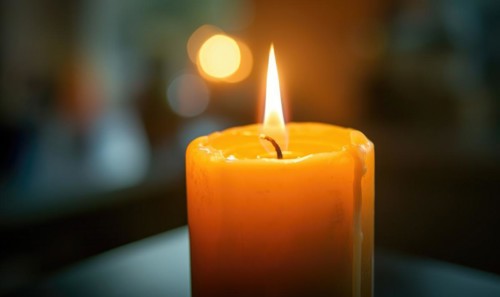 Close-up of a candle burning brightly with soft focus on the flame AI generated