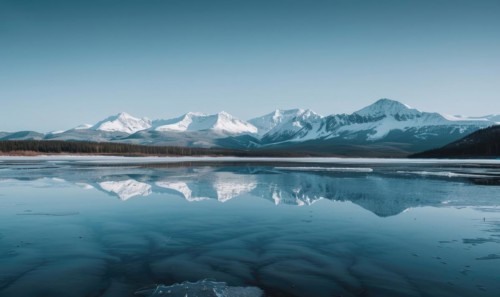 A distant view of snow-capped mountains reflected in the frozen surface of a lake AI generated