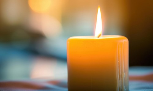 Close-up of a candle burning brightly with soft focus on the flame AI generated