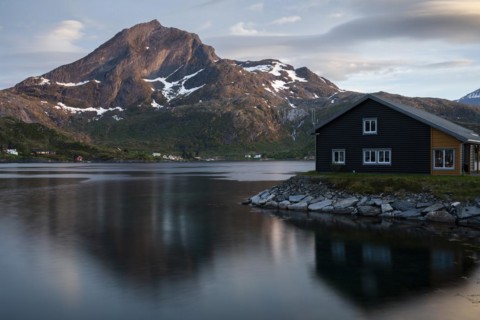 Landscape on the Lofoten Islands. A wooden house in Kakern on Kakersundet. The mountain Narvtinden