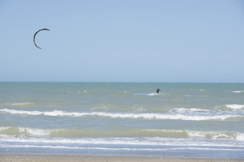Kitesurfing Cutting Through the Waves in a Sunny Summer Day in Emilia Romagna, Rimini, Italy,