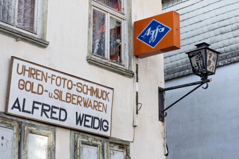 Cantilever sign, AGFA Film und Foto advertising sign, abandoned photo shop with watch shop,