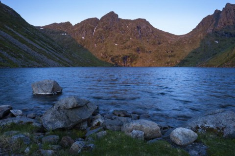 Lake Utdalsvatnet at night at the time of the midnight sun in good weather, blue sky. The mountain