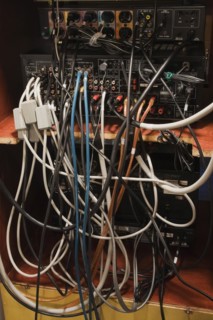 Close-up of assorted tangled audio and video cables connected to various electronic music listening