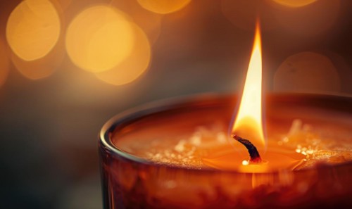 Close-up of a flickering candle flame casting a warm glow AI generated