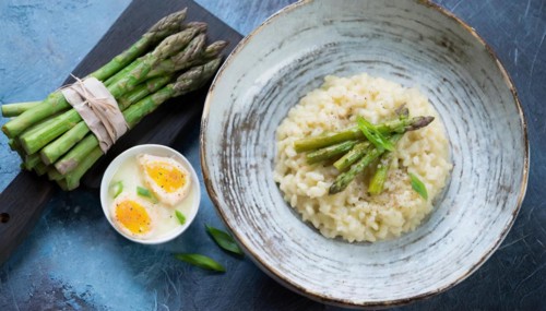 Creamy risotto with asparagus and a poached egg, served on wood, risotto with green asparagus, KI