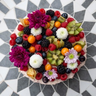 A decorative cake with fruit and flowers on a symmetrical tiled base, Germany, Europe