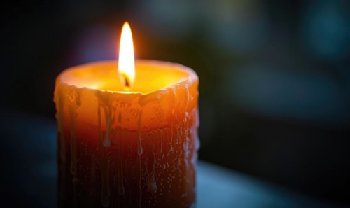 Close-up of a candle's gentle flicker illuminating a serene setting AI generated