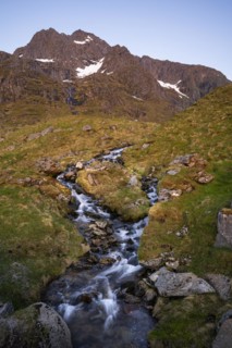 A torrent flows down the Stornappstinden mountain. Long exposure. At night at the time of the