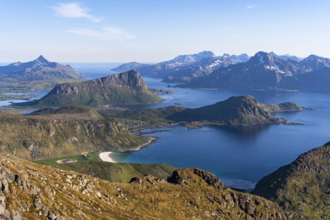 Landscape with sea and mountains. Descent from Himmeltindan mountain. View of the light-coloured
