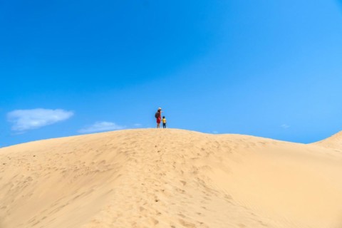 Mother and child walking in the dunes of Maspalomas in summer, Gran Canaria, Canary Islands