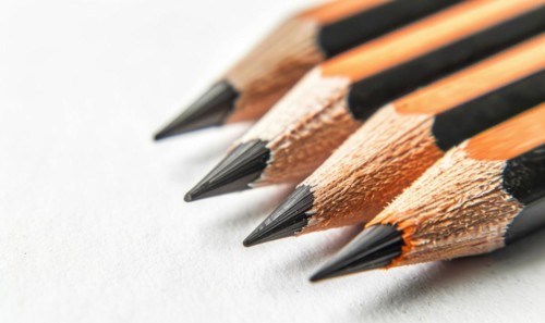 Graphite pencils lying on a blank sheet of white paper AI generated