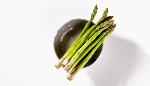 Stylish image of asparagus sticking out of a bowl against a white background, AI generated, AI