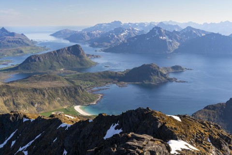Landscape with sea and mountains. Descent from Himmeltindan mountain. View of the light-coloured