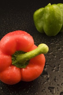 Close-up of freshly picked and washed red and green Capsicum annuum, Bell Peppers on black