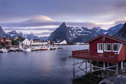 The village of Hamnoy. In the foreground, a typical red wooden house (rorbuer) on wooden stilts.