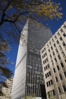 Modern architectural steel and glass office tower constructed between two old buildings framed by