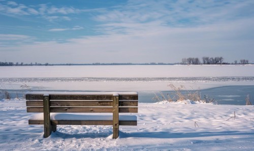 A snow-covered bench overlooking the frozen expanse of a lake AI generated