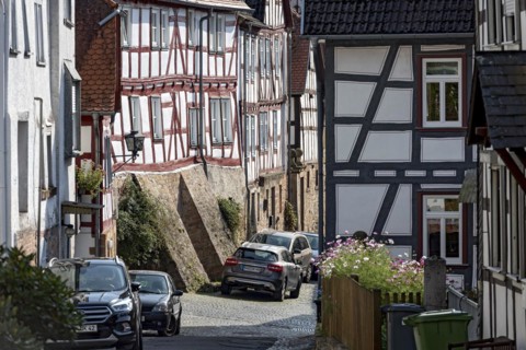 Old half-timbered houses on a narrow alley, parked cars, Untergasse, old town, Ortenberg,