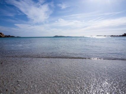 Waves reach the sandy beach, glittering sea, Capriccioli beach, Costa Smeralda, Sardinia, Italy,