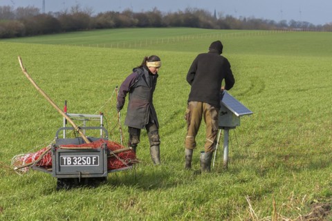 Shepherd and his daughter fence a new pasture with a solar panel for the electric fence,
