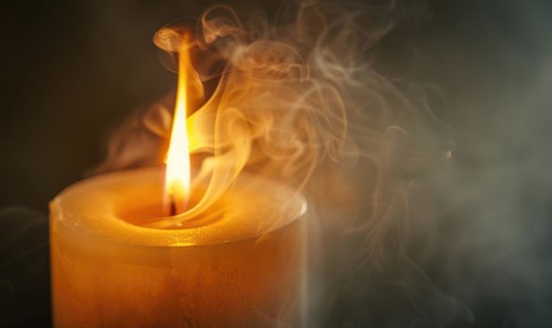 Close-up of a candle with wisps of smoke rising from the flame AI generated