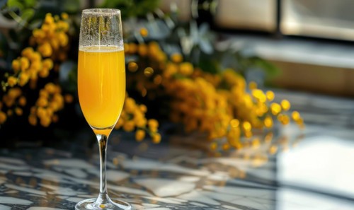 Cocktail in a glass goblet with mimosa branches in the background AI generated