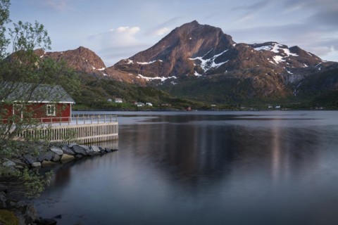 Landscape on the Lofoten Islands. A red wooden house in Kakern on Kakersundet. The mountain