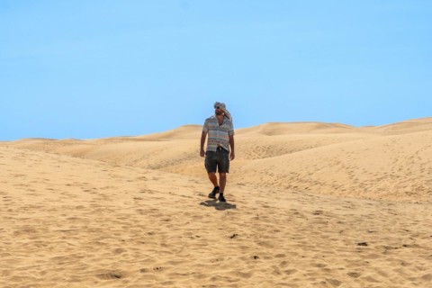 Tourist man with turban in summer walking in the dunes of Maspalomas, Gran Canaria, Canary Islands