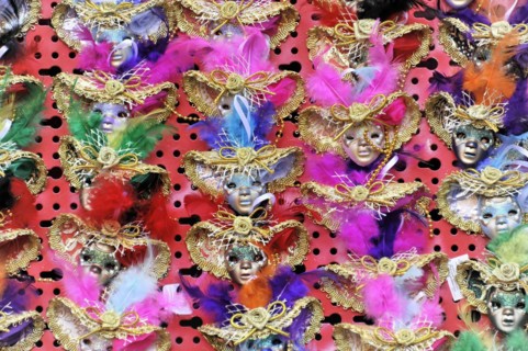 Colourful carnival masks with feather decorations present the lively celebration of the Venetian