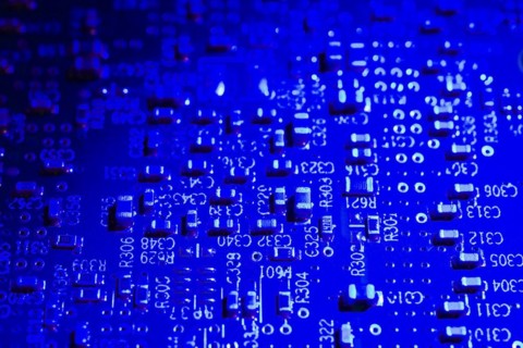 Close-up of blue lighted electronic computer circuit board with white numbers and letters, Studio