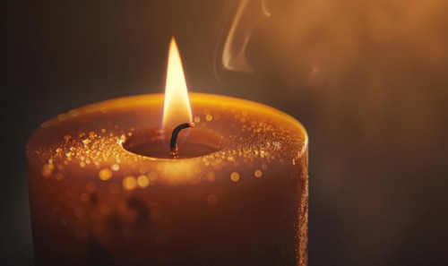 Close-up of a candle's gentle flicker illuminating a serene setting AI generated
