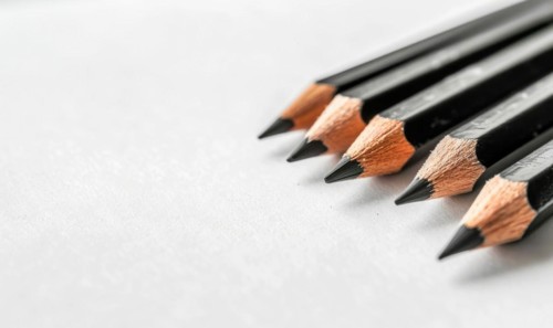 Graphite pencils lying on a blank sheet of white paper AI generated