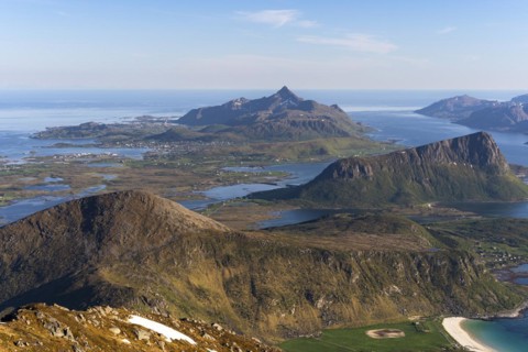 Landscape with sea and mountains. Descent from Himmeltindan mountain. View of the light-coloured