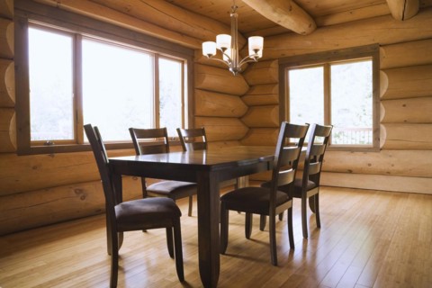 Dark brown stained wooden table and upholstered seat high back chairs in dining room with