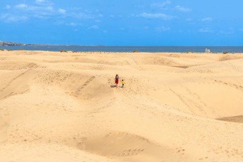 Mother and child walking on summer holidays in the dunes of Maspalomas, Gran Canaria, Canary