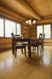 Dark brown stained wooden table and upholstered seat high back chairs in dining room with