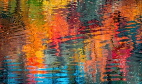 The vibrant colors of autumn reflected in the crystal-clear waters of the lake AI generated
