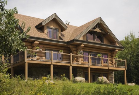 Rear of large two story luxurious Scandinavian style log cabin home with timber design elements and