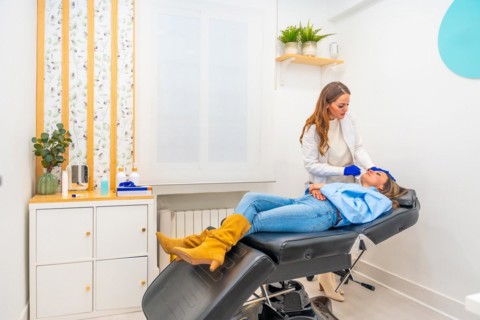 Cosmetologist working in a innovative beautician clinic injecting hyaluronic acid to the face of a